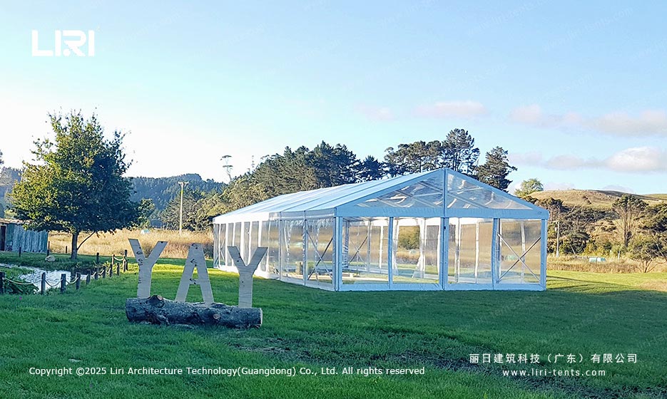 Clear top lawn tent exterior beside a YAY event sign